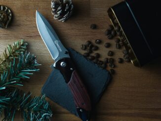 brown and silver folding knife on brown wooden table