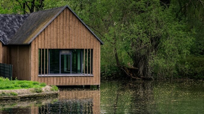 brown wooden cabin near river at daytime