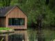 brown wooden cabin near river at daytime