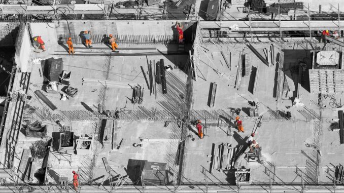 selective color photo of man on top of gray building