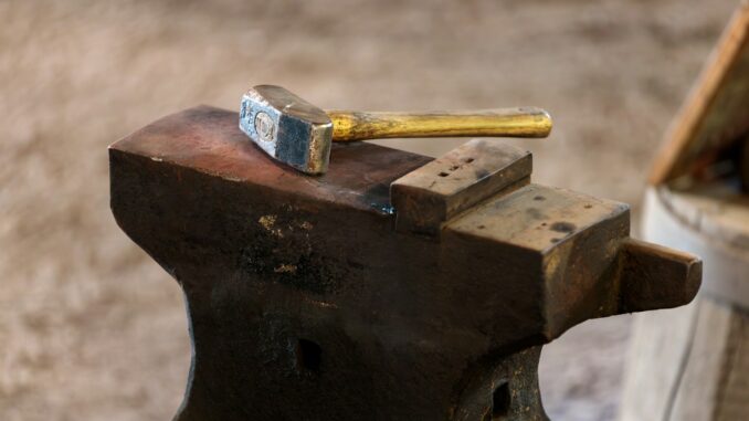 a hammer and a block of wood on top of a bench