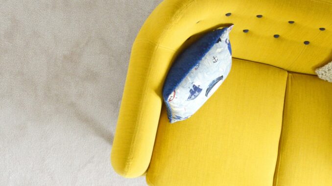 yellow fabric sofa with throw pillow