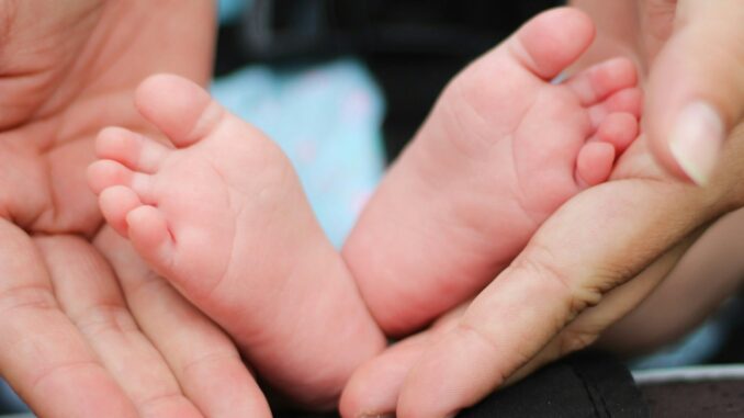 person holding baby feet